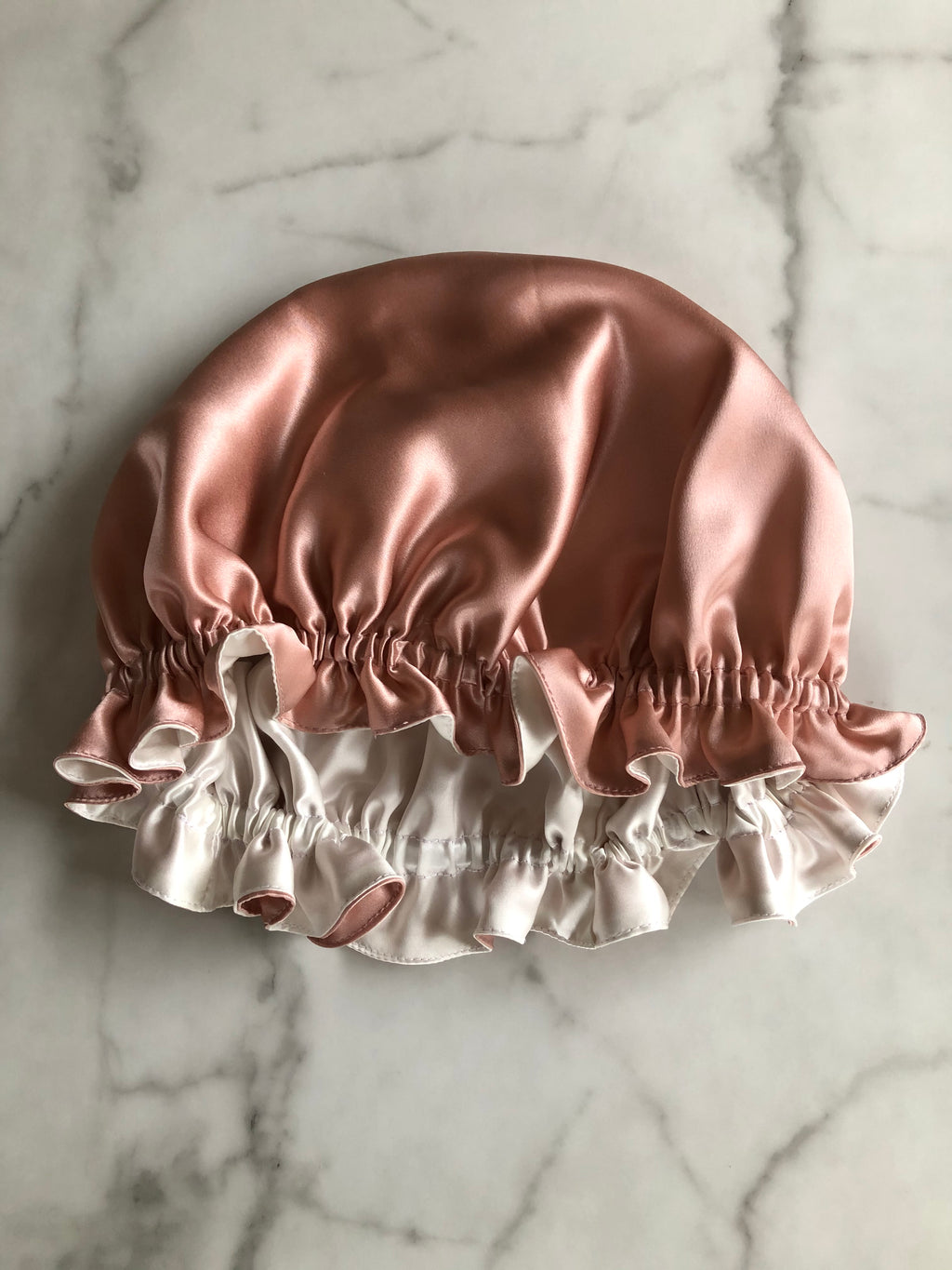 Silky satin hair bonnet on a marble surface