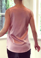 Person wearing a silk pink top 